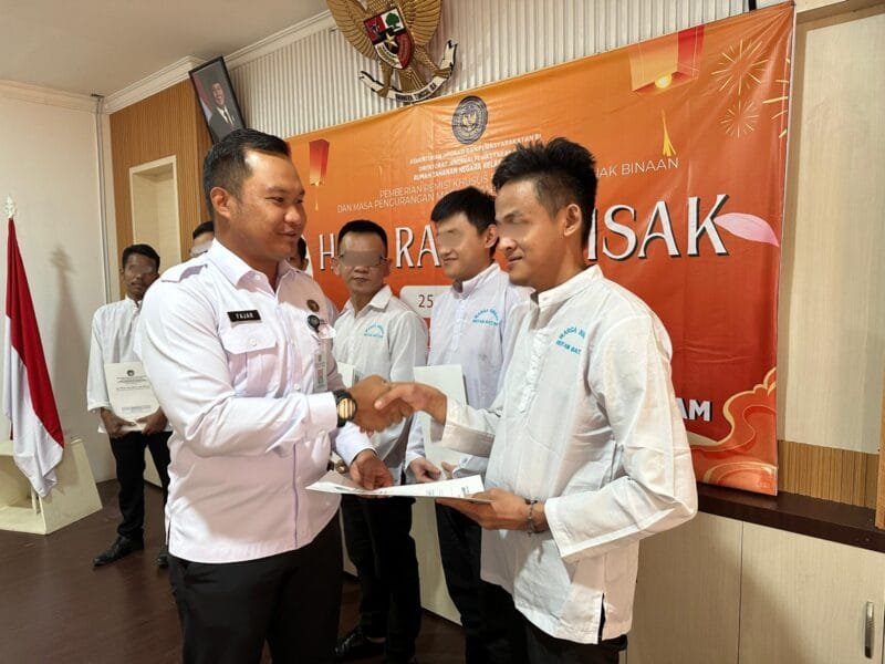 Karutan Batam Fajar bersalaman dengan warga binaan yang memperoleh remisi Waisak pada Senin (13/5/2025). Foto:dok/Humas Rutan